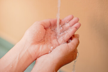 Fototapeta premium A woman's hand is running water from a faucet to clean her hands.