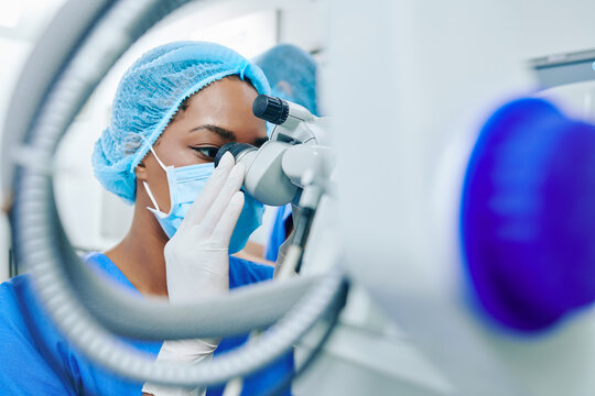 Young Black Female Ophthalmologist Looking Through Surgical Microscope Before Starting Laser Correction Surgery