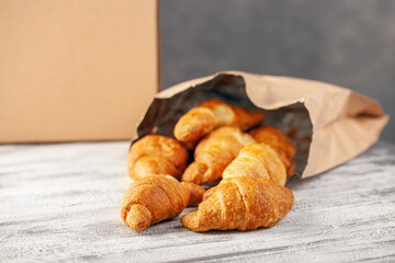 Croissants in a paper bag. Food delivery online order. Quarantine concept.