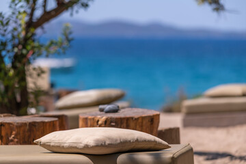 Pillow and wooden furniture on the beach with the sea in the background