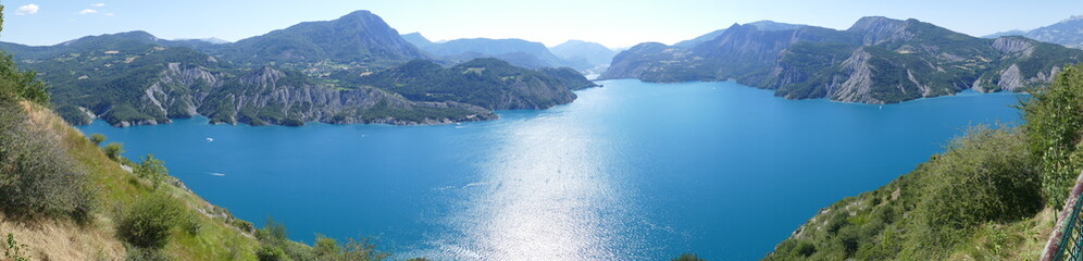 Obraz premium Panoramique : magnifique lac de Serre Ponçon devant la montagne alpine