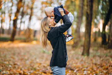 Happy mother with her little baby son have fun in the city park