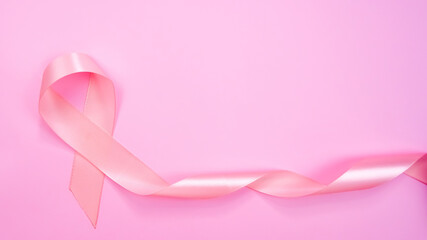Top view of Pink ribbon on pink background with copy space, Breast cancer symbol, Breast cancer awareness month. Important days in October