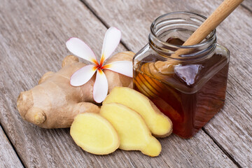 Tumeric ( curcumin, curcuma longa Linn) root and  jar of honey isolated on wood table background.