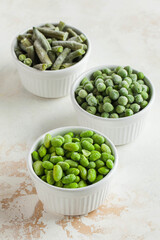 Frozen vegetables such as green peas, soy, green beans and baby in white bowls. Healthy food, frozen food