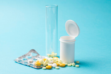 Medical container with various tablets on a blue background