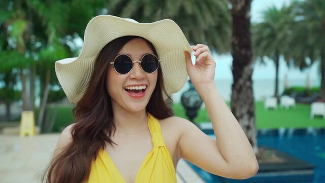 slow-motion of cheerful woman in yellow dress near the pool and the beach

