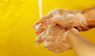 A woman washes her hands with soap under the tap. Hand disinfection during the coronavirus epidemic.