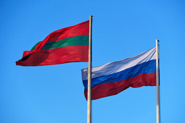 Fototapeta na wymiar the national flag of Transnistria and Russia against the sky