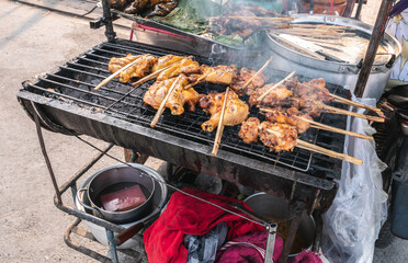 Fried chicken on the grill of a street food stall in Ayutthaya, Thailand.