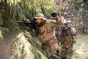 Fototapeta premium Military leader looking though rifle scope and preparing his team for attack