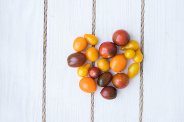 Heart shaped tomatoes. white wood background. soft focus. top view