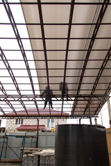 A worker mounts a metal canopy