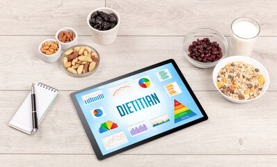 Organic food and tablet pc showing DIETITIAN inscription, healthy nutrition composition