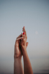 intertwined hands of a man and a woman on a gray background,