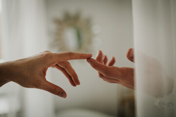 Hands of a man and a woman against the background of a blurred window. The gentle touch of a man and a woman. Love connection help concepts. Be hand in hand.