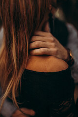 The girl holds her hand on her shoulder. Back view. Woman's head and shoulder. Hand of a young woman.