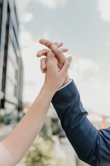 Male and female hands reach out to each other and touch the sky with their fingers.