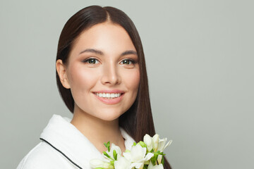 Beautiful woman brunette after bath holding white flowers and smiling