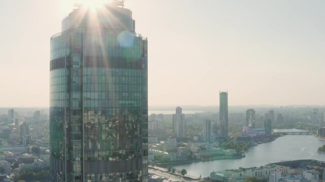 Top view of city reflected in windows of glass business skyscraper. Stock footage. Beautiful reflection of city in glass skyscraper on background city panorama on sunny day