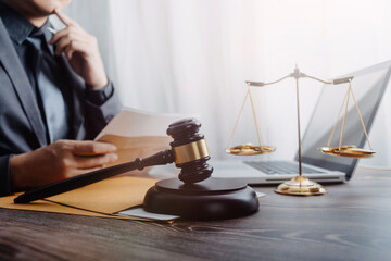 Business and lawyers discussing contract papers with brass scale on desk in office. Law, legal services, advice, justice and law concept picture with film grain effect