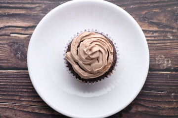 Top view of chocolate cup cake on wooden table.