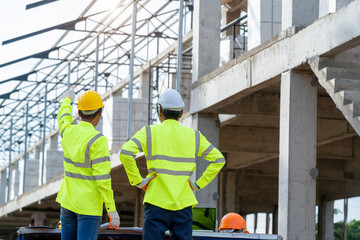 Engineer discussing with  architect about project in building construction site