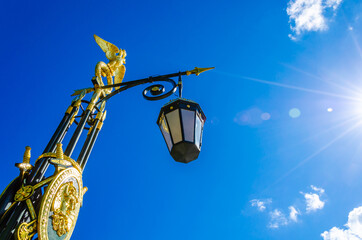 Fototapeta na wymiar Antique lantern with gilt on a pole on the street.