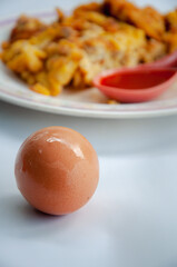 Whole raw brown chicken eggs with omelet background