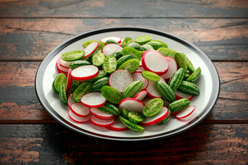 Cucamelon radish salad on rustic wooden table. healthy summer food