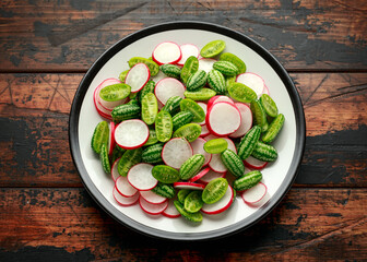 Cucamelon radish salad on rustic wooden table. healthy summer food