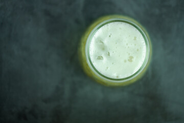Beer glass with foam on a black background.