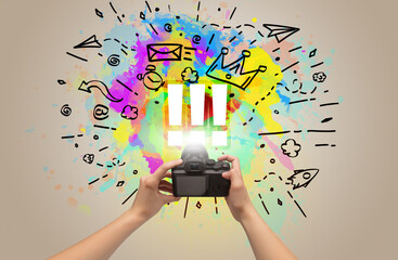 Close-up of a hand holding digital camera with abstract drawing and !!! inscription