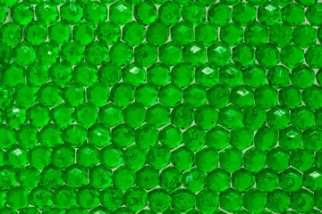 Close up of translucent green crystals. Green beads glittering and shining in the light