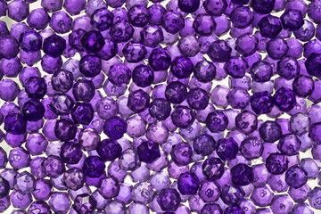 Close up of translucent purple crystals. Purple beads glittering and shining in the light