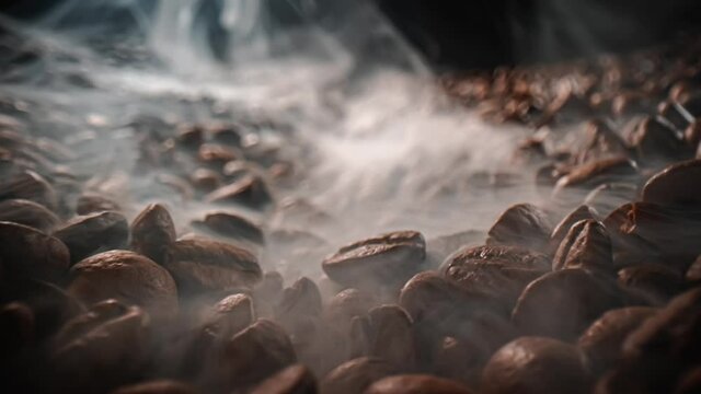 Close up of seeds of coffee. Fragrant coffee beans are roasted smoke comes from coffee beans.