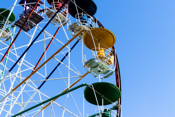 Ferris wheel cabins against blue sky