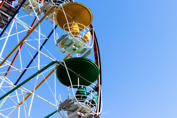 Ferris wheel cabins against blue sky