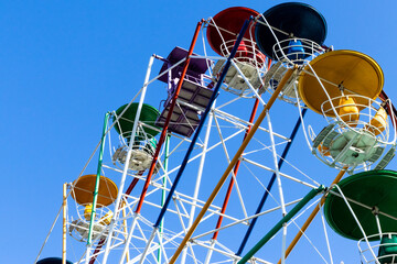 Ferris wheel cabins against blue sky