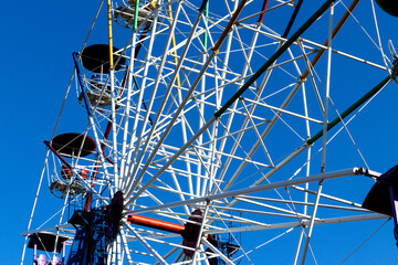 Ferris wheel cabins against blue sky