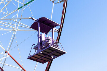 Ferris wheel cabins against blue sky