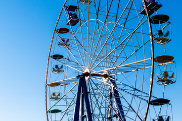 Ferris wheel cabins against blue sky