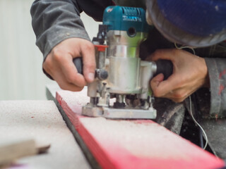 the man handles the product with a hand mill. woodwork.