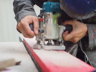 the man handles the product with a hand mill. woodwork.