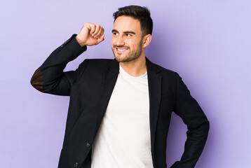 Young caucasian man isolated on purple background celebrating a victory, passion and enthusiasm, happy expression.