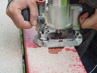 the man handles the product with a hand mill. woodwork.