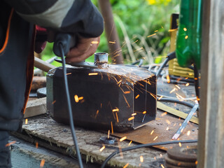 a man handles metal with an angle grinder. sparks from metal.