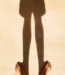 Junge barfuß steht im Sonnenschein Schatten auf Boden Beine und kurze Hose zu sehen Zehen Fuß...