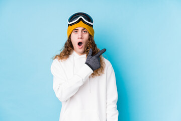 Young caucasian man wearing a ski clothes isolated  pointing to the side