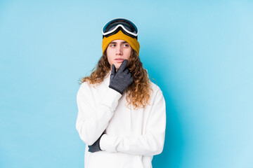 Young caucasian man wearing a ski clothes isolated  relaxed thinking about something looking at a copy space.